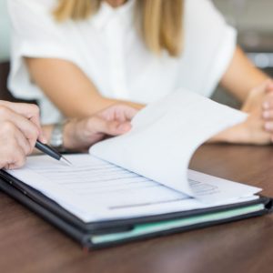 Hands of male executive showing contract to female partner