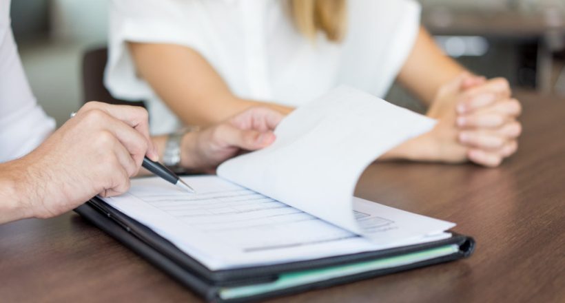 Hands of male executive showing contract to female partner