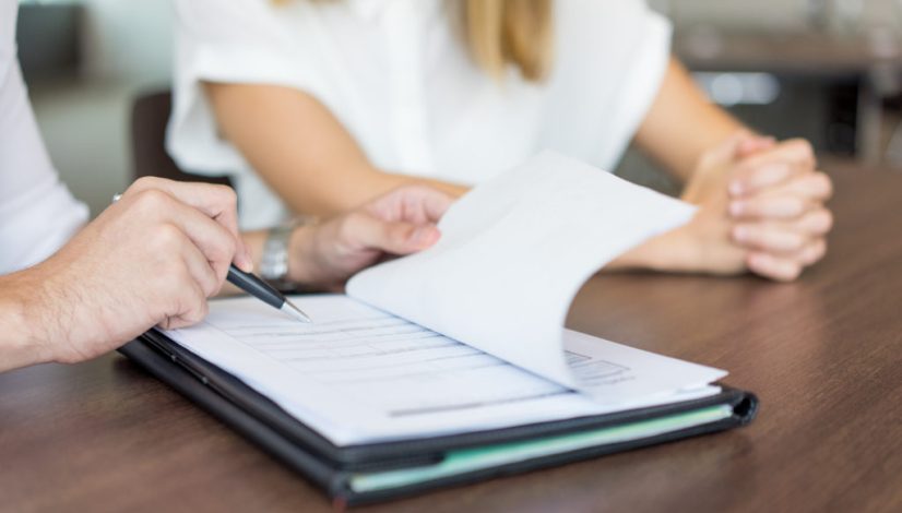 Hands of male executive showing contract to female partner