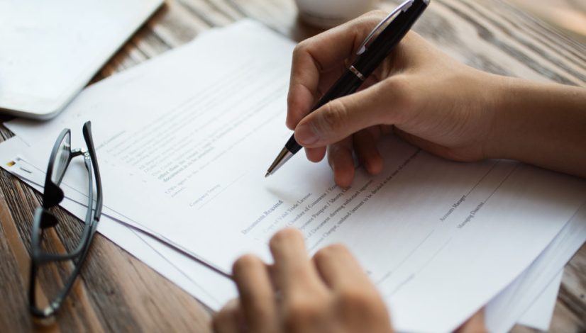 Businessman examining papers at table