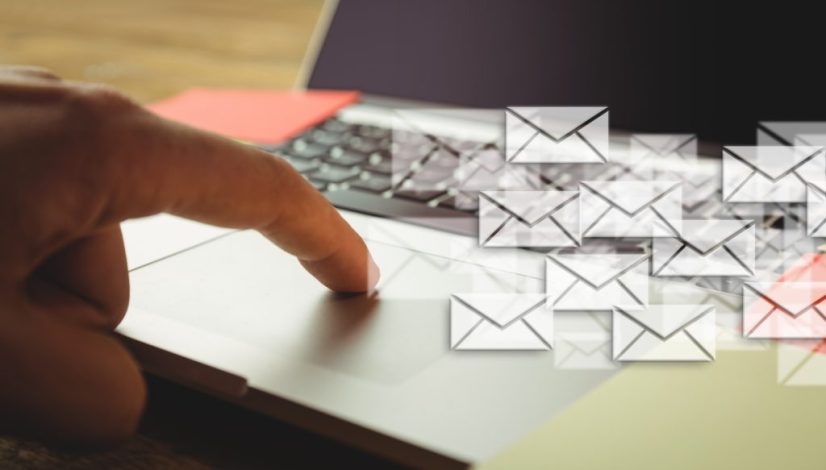 Composite image of hand using laptop put on a desk with letter icons