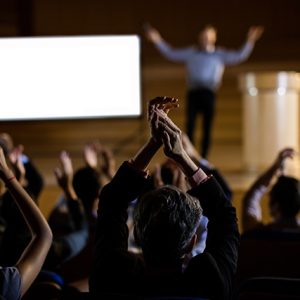 Audience applauding speaker after conference presentation at conference center