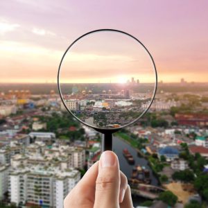 Magnifying glass and cityscape in focus, business vision