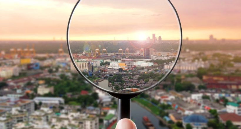 Magnifying glass and cityscape in focus, business vision