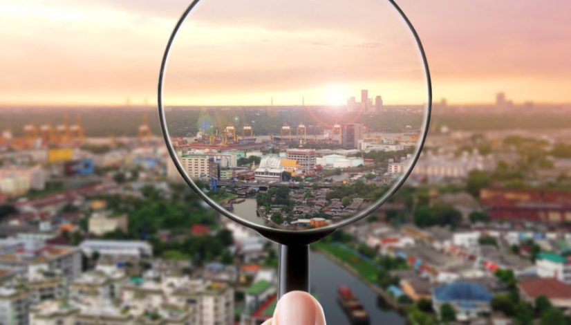 Magnifying glass and cityscape in focus, business vision